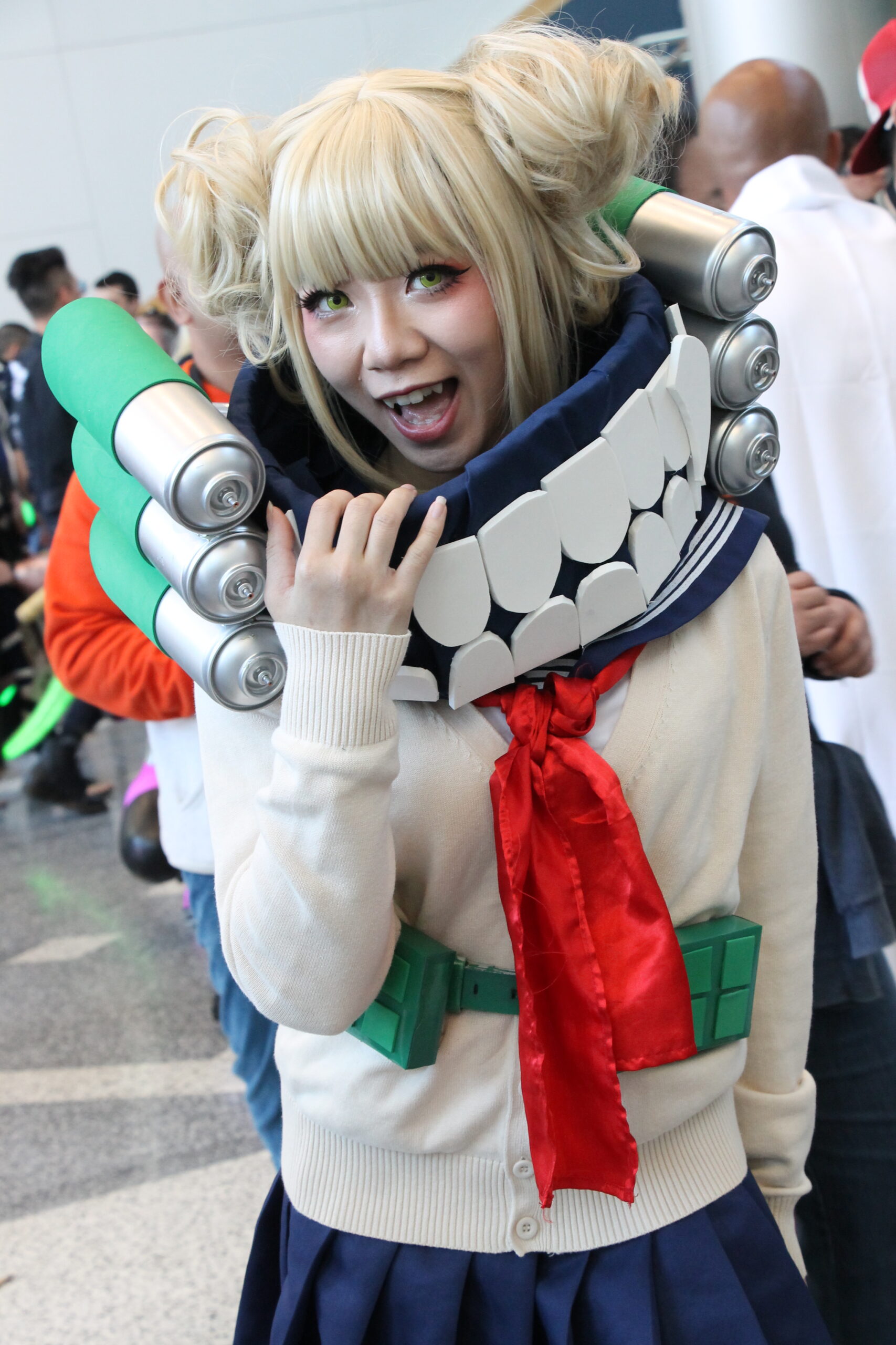 Himiko Toga cosplayer with blonde buns and fangs at an anime convention