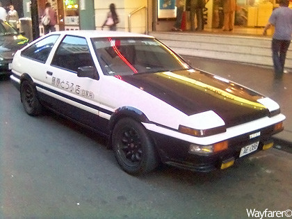 Black and white Panda Trueno AE86 with the Fujiwara Tofu Shop door decal