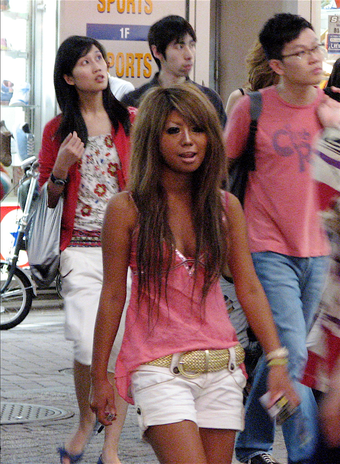 Real gyaru street fashion with dark tan and bleached hair in Shibuya Tokyo